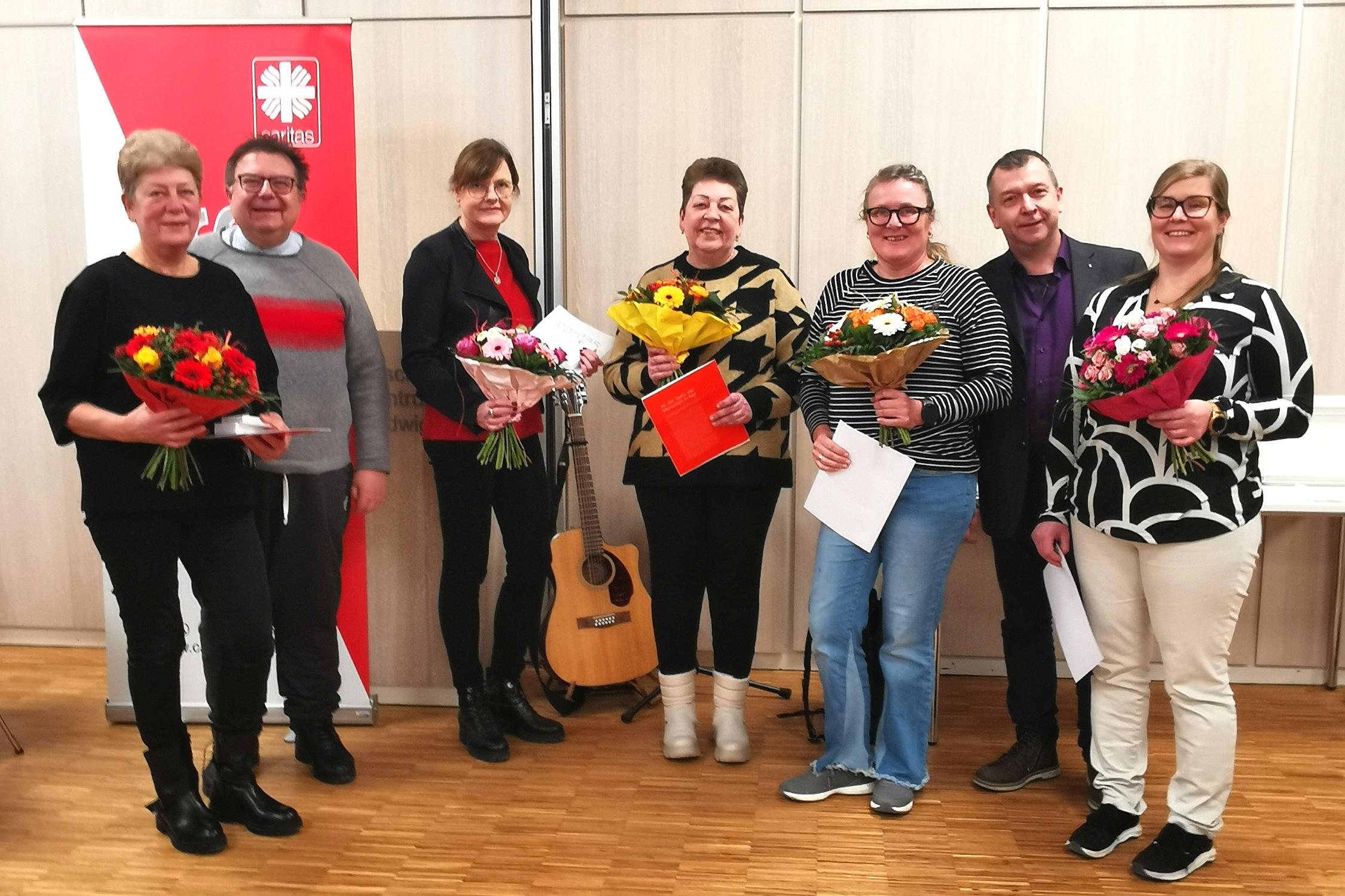 Gruppenfoto mit Blumen und Gitarre: Lili Herterle, Alla Merz, Vorstandsvorsitzender Hans-Peter Kunert, Brigitte Guggenberger, Karin Heinritz, Geschäftsführer Sebastian Grund und Marylin Krug (v.l.n.r.)